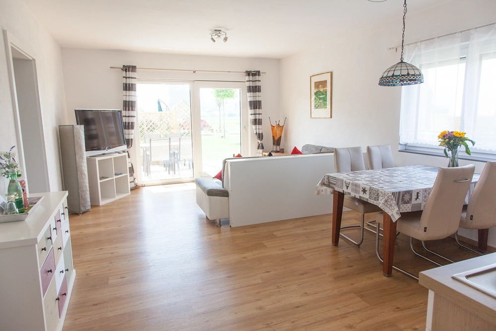 „Hahns Herberge“ – Wohnzimmer mit Blick auf die Terasse - Interiorfoto mit übersichtlicher Raumstruktur.